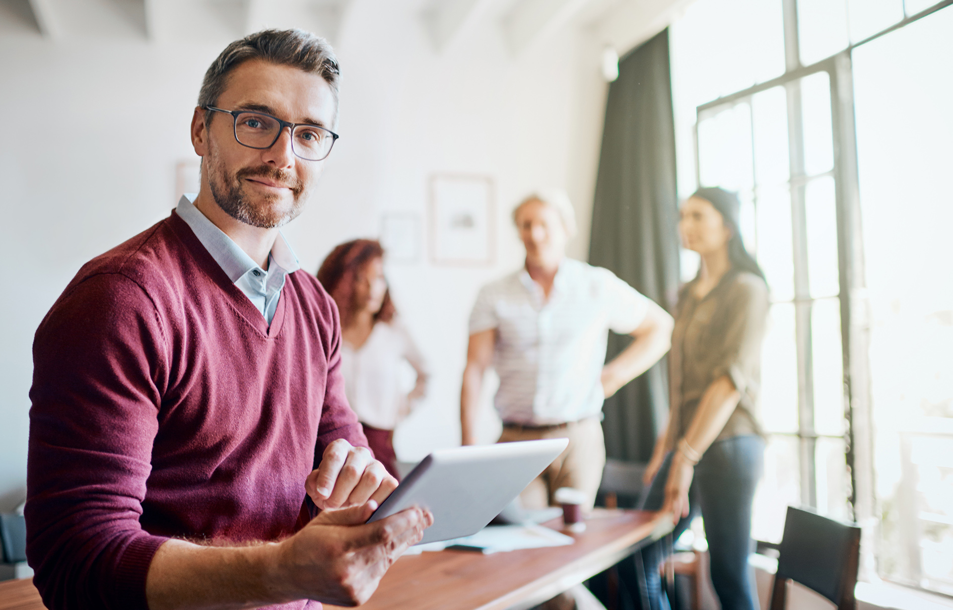 Man standing in office holding documents