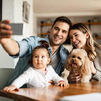Family of three taking a selfie with their dogs 