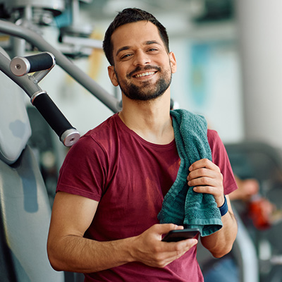 Person in a gym holding a phone and a towel