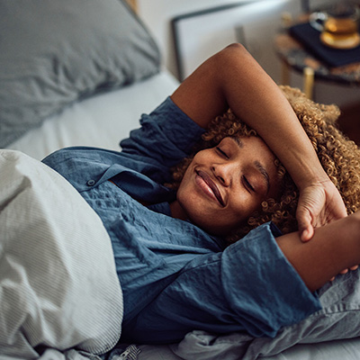 Woman wearing blue lying in bed