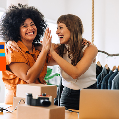 Two people high fiving and smiling