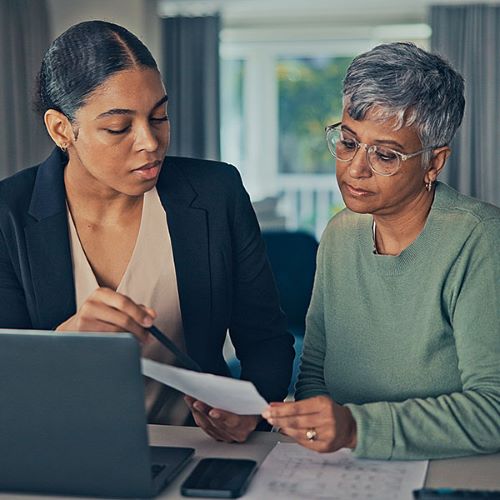 Younger Woman looking at Paper with Older Woman
